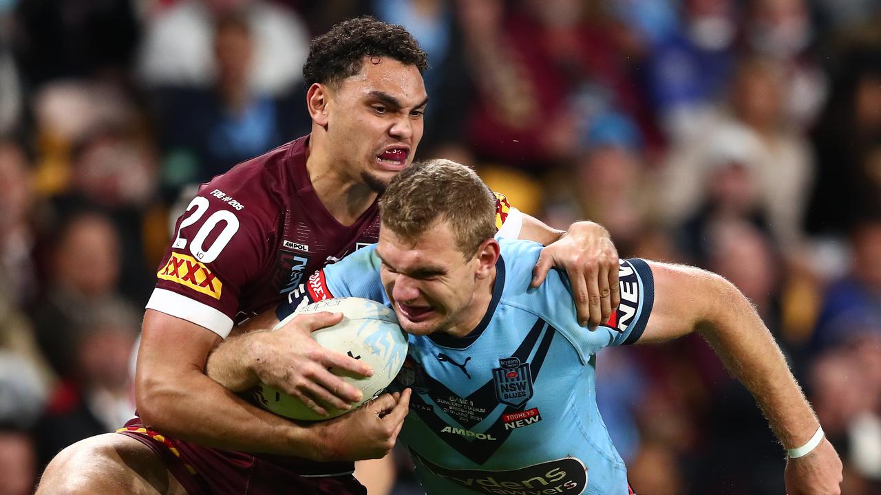 Blues star Tom Trbojevic tries to break the tackle of Maroons winger Xavier Coates. Picture: Chris Hyde/Getty Images