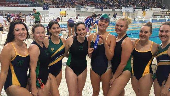 Brigidine College student Tiare Matapo, wearing cap, is surrounded her friends after winning at the CaSSSA swimming carnival.