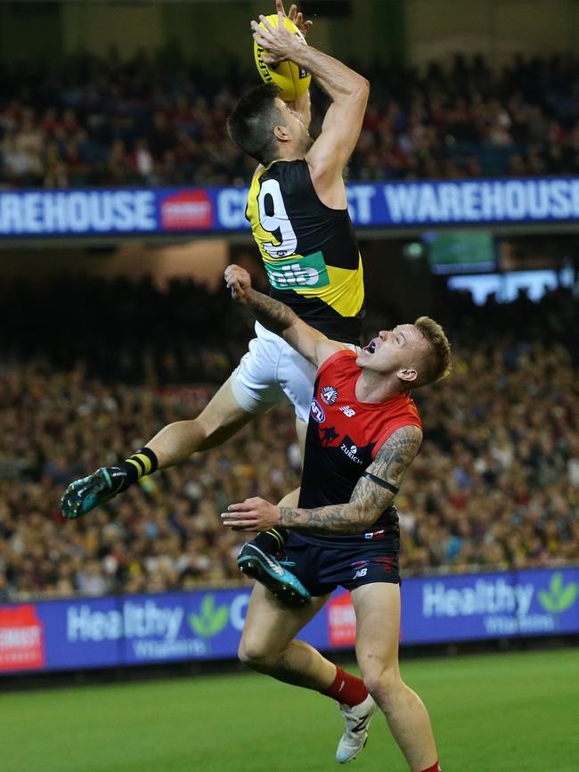 Tigers skipper Trent Cotchin got the crowd roaring with this speccy over James Harmes. Picture: Michael Klein