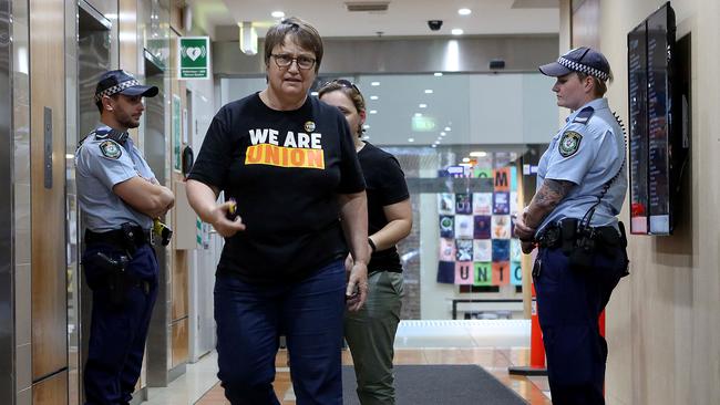  A police officer guards the lifts of the AWU’s Sydney offices as bemused onlookers pass by.  Picture: James Croucher