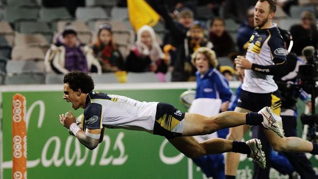 Matt Toomua dives over to score one of his three tries for the Brumbies against the Force.