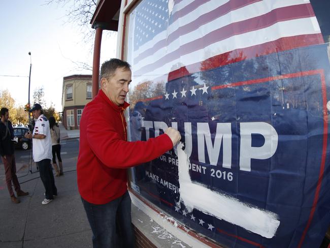 Jeff Eggemeyer, Denver co-chair of the Trump Campaign Colorado, cleans paint from a storefront window after finding “Trump=Thief” and other insults painted all over the building. Picture:David Zalubowski/AP