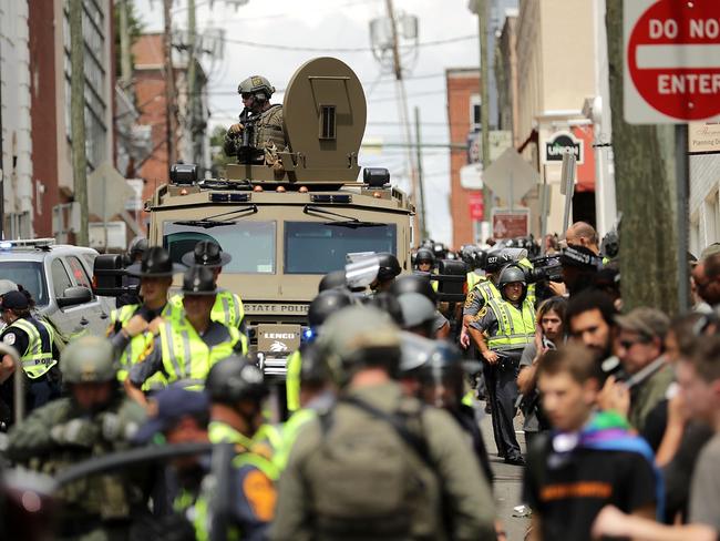 A Virginia State Police officer in riot gear keeps watch from the top of an armoured vehicle after a car drove through a crowd of counter-demonstrators during a race hate march. Picture: Chip Somodevilla/Getty Images/AFP