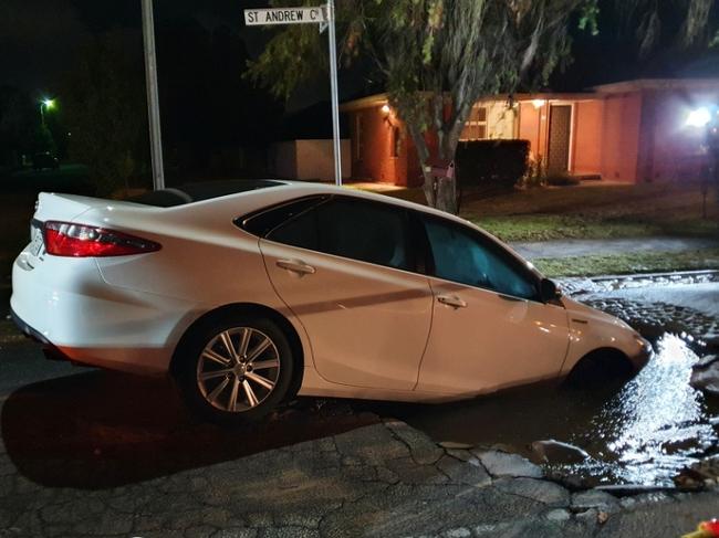 MUST CREDIT . A car has been half swallowed by a sinkhole that opened up on a road at Novar Gardens. Picture: SA Police