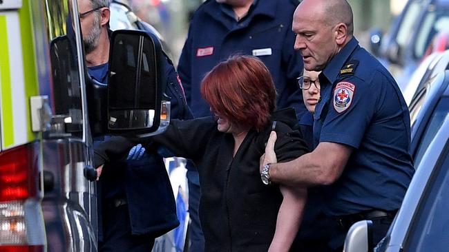 The woman was assisted by paramedics after collapsing in a street next to where the injection centre announcement was being made. Picture: Joe Castro/AAP
