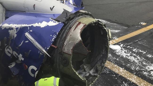 The engine on a Southwest Airlines plane is inspected as it sits on the runway at the Philadelphia International Airport after it made an emergency landing in Philadelphia, Tuesday, April 17, 2018. (Amanda Bourman via AP)