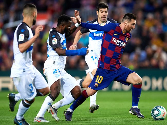 BARCELONA, SPAIN - DECEMBER 21: Lionel Messi of FC Barcelona eludes the pressure from Ruben Duarte, Wakaso Mubarak and Manu Garcia of Deportivo Alaves to score his team's third goal during the La Liga match between FC Barcelona and Deportivo Alaves at Camp Nou on December 21, 2019 in Barcelona, Spain. (Photo by Alex Caparros/Getty Images) ***BESTPIX***