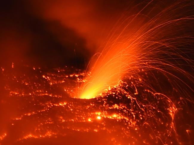 A photo taken on January 25, 2018 from the city of Legazpi, Albay province, south of Manila, shows a fiery fountaining during an eruption of the Mayon volcano as it emits molten lava.  Philippine authorities who have declared a no-go zone around an erupting volcano said January 25 they will remove all holdouts, by force if necessary, to avoid casualties after tens of thousands of other residents fled to safety. / AFP PHOTO / TED ALJIBE