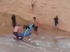 Surfers and beachgoers rescue a man swept away by the powerful current as water rushed from the entrance to Dee Why Lagoon into the ocean at Long Reef Beach on February 23, 2022. Image: Instagram - skykmonkey5.