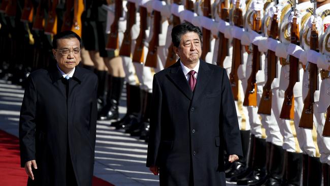 Japanese Prime Minister Shinzo Abe, right, and Chinese Premier Li Keqiang review an honour guard in Beijing yesterday. Picture: AP