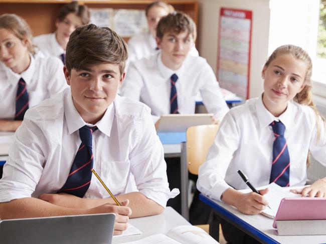 Students Listening To Female Teacher In Classroom