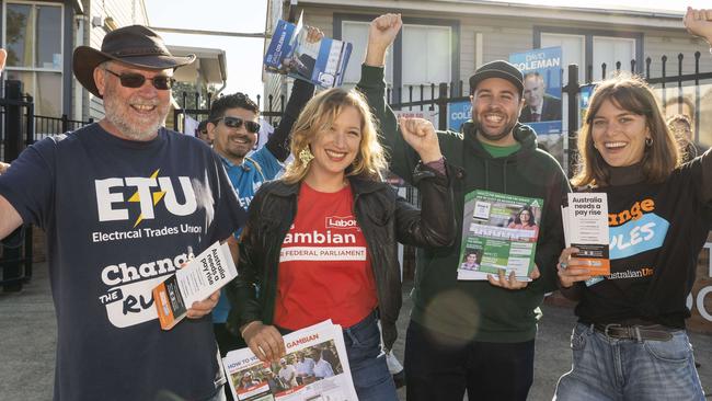 Campaign volunteers come together for a smile at the Panania North Public School polling booth. Picture: Matthew Vasilescu