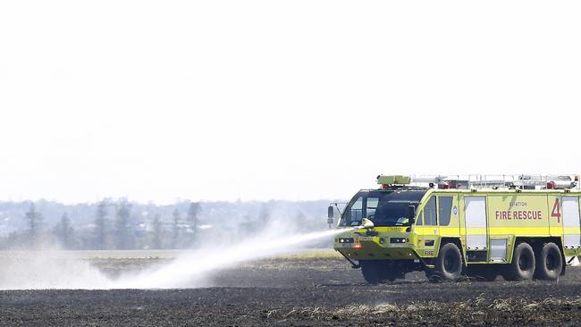 An aviation fire truck extinguishing spots still smoldering at Sydney Airport after the engine failure. Picture: NewsWire / John Appleyard