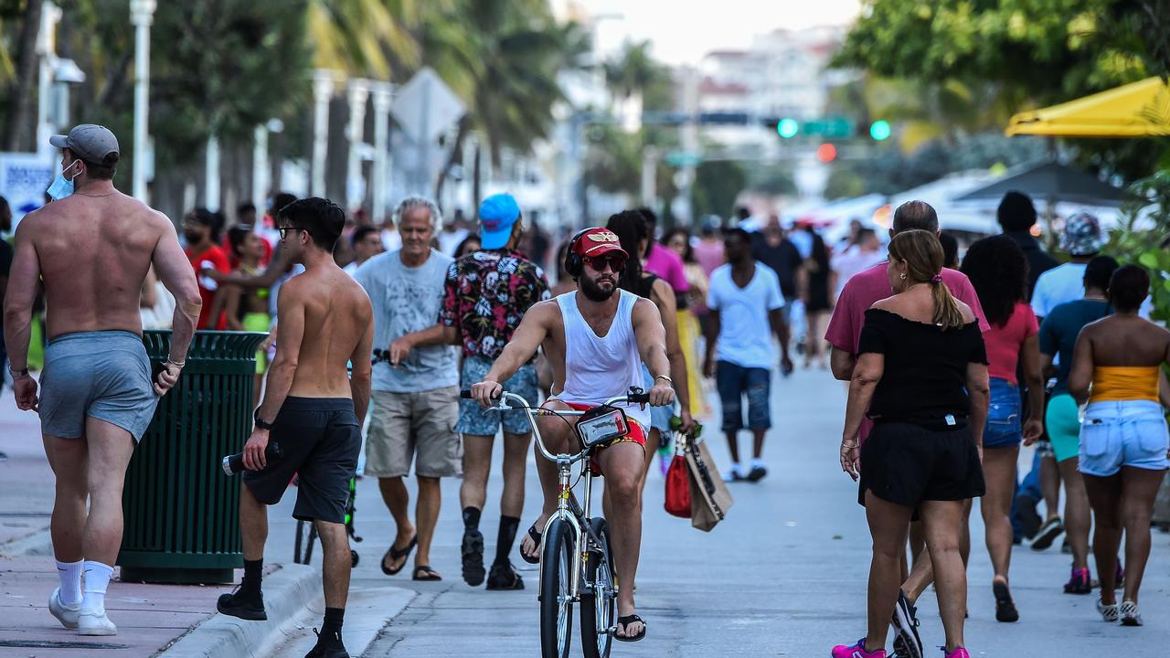 Beachgoers walk on Miami Beach, Florida as COVID-19 cases in the state surge. Picture: CHANDAN KHANNA / AFP.