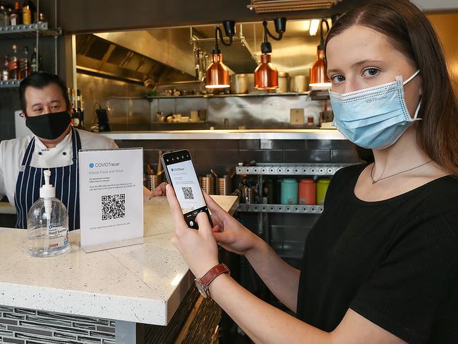 MELBOURNE, AUSTRALIA-NewsWire Photos SEPTEMBER 30, 2020 : Imbue Food and Wine Restaurant owner Phong Nguyen looks on as Lisa Kowal scans her phone using COVIDTracer technology.The technology by the company Corplite, has been provided free and is being used by councils and courthouses. Picture : NCA / NewsWire / Ian Currie