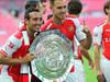 (L-R) Arsenal's Spanish midfielder Santi Cazorla and Arsenal's Welsh midfielder Aaron Ramsey pose with the Community Shield trophy after Arsenal won the FA Community Shield football match between Arsenal and Manchester City at Wembley Stadium in north London on August 10, 2014. AFP PHOTO / CARL COURT -- NOT FOR MARKETING OR ADVERTISING USE / RESTRICTED TO EDITORIAL USE