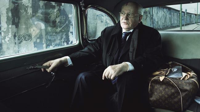 Former Soviet leader Mikhail Gorbachev sits in a car, a Vuitton bag at his side and the Berlin Wall in the background. Picture: Annie Leibovitz