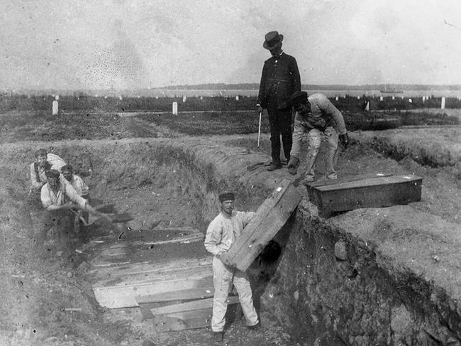 Gravediggers in earlier times prepare an unmarked mass burial on Hart Island. Picture – Supplied