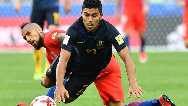 Australia's midfielder Massimo Luongo stumbles against Chile's midfielder Arturo Vidal.