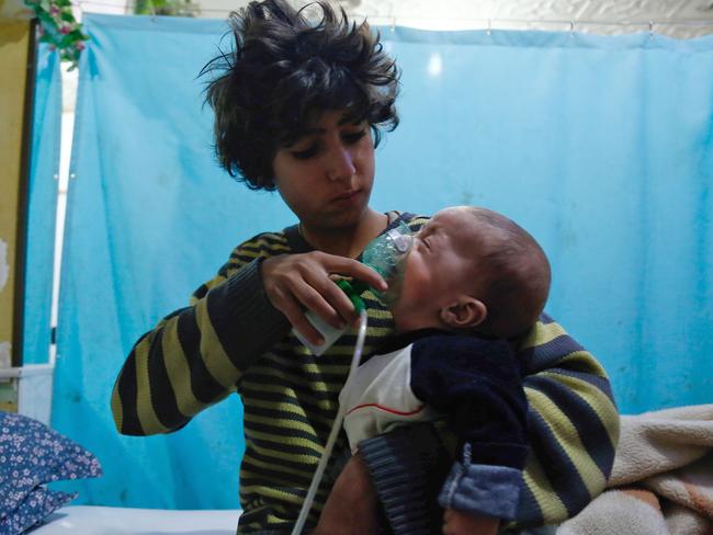 A Syrian boy holds an oxygen mask over the face of an infant at a makeshift hospital following a reported gas attack on the rebel-held besieged town of Douma. Picture: AFP