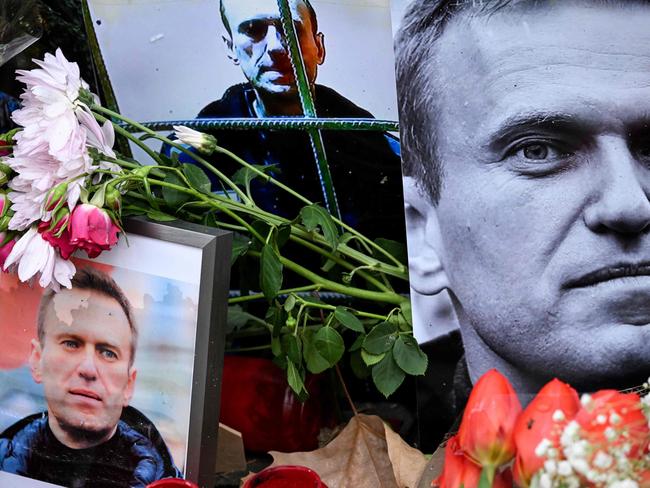 Flowers are seen placed around portraits of late Russian opposition leader Alexei Navalny, who died in a Russian Arctic prison, at a makeshift memorial in front of the former Russian consulate in Frankfurt am Main, western Germany, on February 23, 2024. (Photo by AFP)