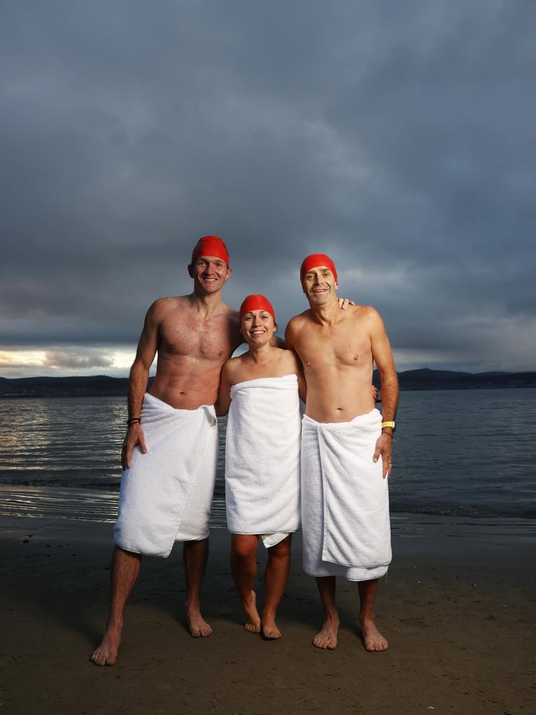 Dave Abrey of Brisbane, Sabrina Carter of Launceston, Glen Harvey of Sydney who became friends after meeting on the beach during the solstice swim one year and now meet up each year to do the swim together. Dark Mofo Nude Solstice Swim 2024 at Long Beach Sandy Bay. Picture: Nikki Davis-Jones