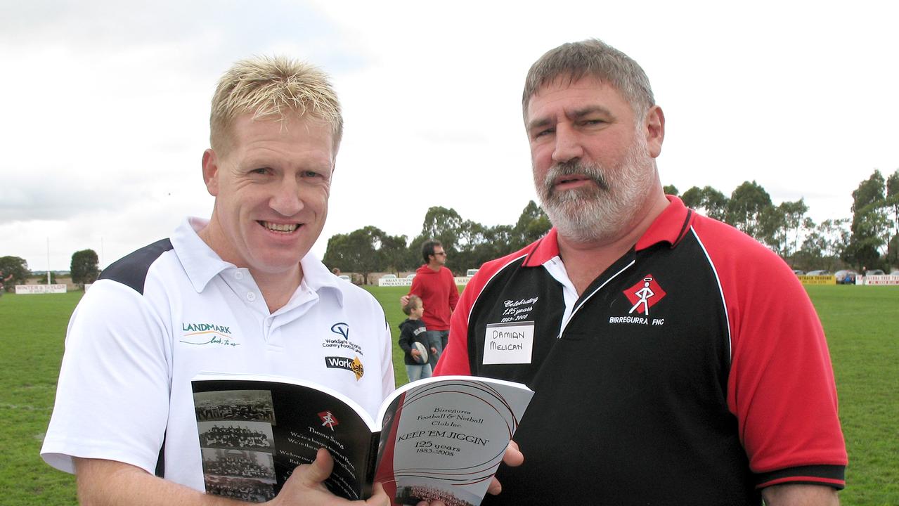 Birregurra Football Club VCFL training manager and Carlton premiership player Dean Rice looks over club history book Keep em Jiggin with Saints president Damian Melican