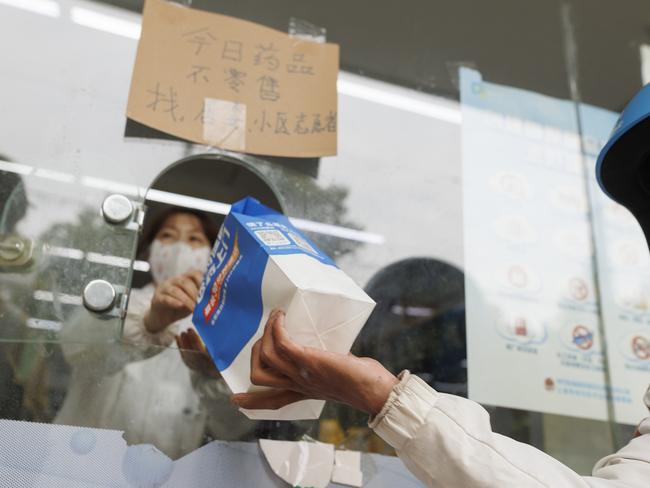 A delivery rider gets a bag of medicine from a pharmacy in Shanghai, China. Picture: Getty Images