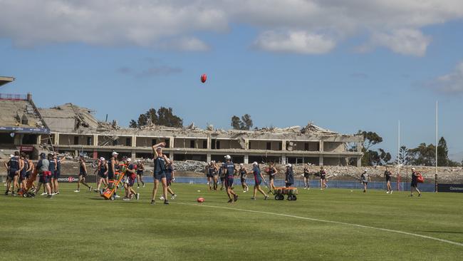 Adelaide players at pre-season training at Football Park last week amid demolition of the grandstands. Picture SIMON CROSS —