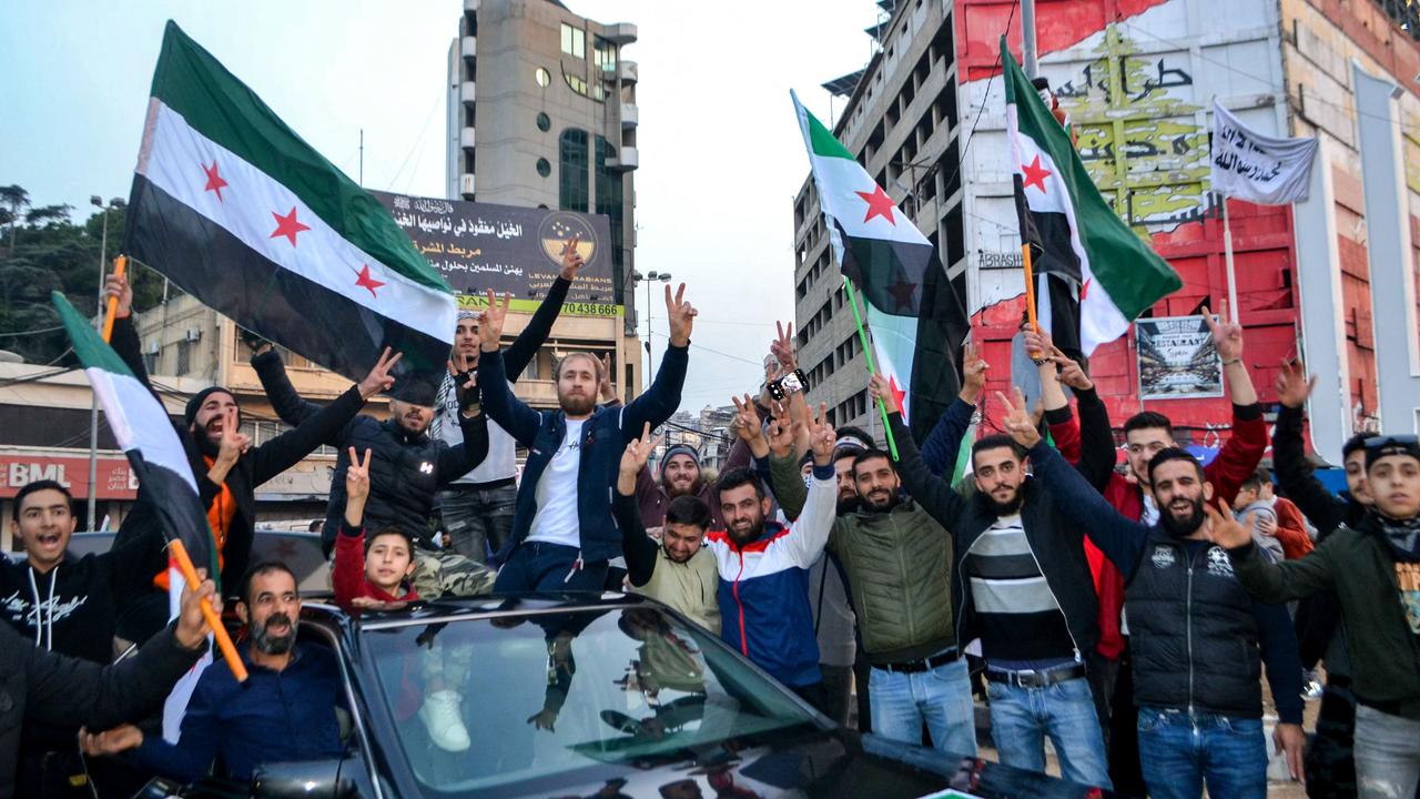 Syrian and Lebanese people in the northern Lebanese city of Tripoli celebrate after Islamist-led rebels declared that they have taken the Syrian capital in a lightning offensive, sending President Bashar al-Assad fleeing and ending five decades of Baath rule in Syria. Picture: Fathi Al-Masri/AFP