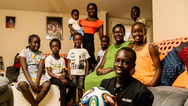 Jok Akuien, 15, holding a soccer ball, with the 10 members of his household at Blakeview. (AAP Image/ Morgan Sette)