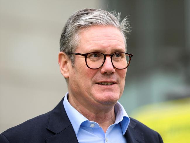 Britain's Prime Minister Keir Starmer reacts as he speaks with members of staff of Ambulance Service, outside of London ambulance service dockside centre, in London, on October 21, 2024, during a visit. (Photo by Jaimi Joy / POOL / AFP)