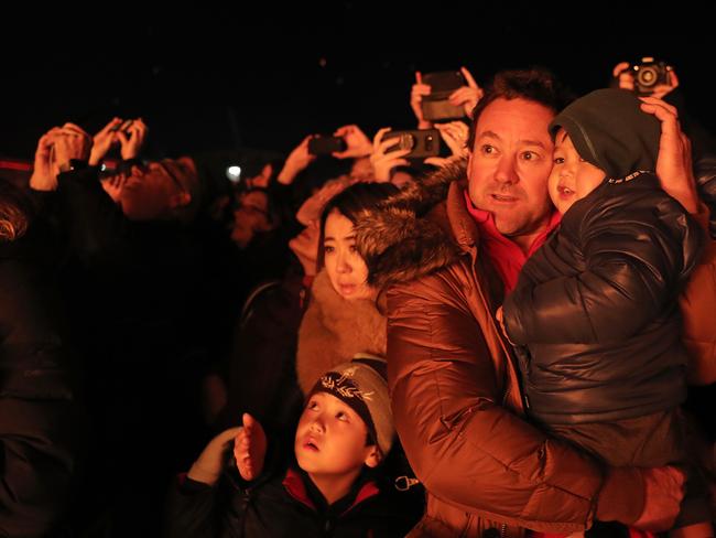 The Merrick family from Lindisfarne, Koa, 7, left, Miyami and Glenn holding Keito, 3, watch the Ogoh-Ogoh alight at The Burning at Dark Park. Picture: LUKE BOWDEN