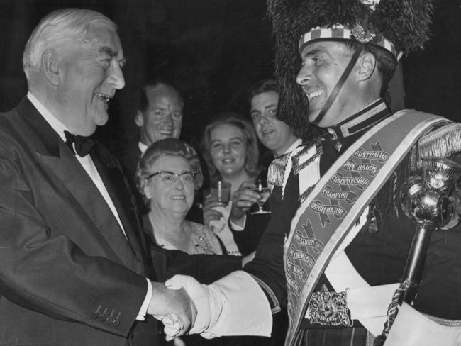 Sir Robert Menzies shakes hands with Hawthorn City Pipe Band drum major Bob Semple during his farewell celebration.