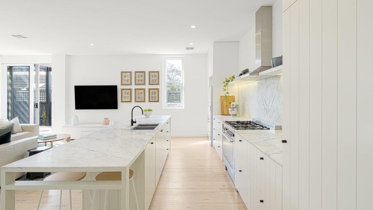 The kitchen is fitted with European stainless-steel appliances and a marble island.