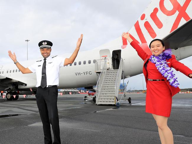 The flight crew of the first Virgin Australia flight to arrive at the Gold Coast Airport just minutes after the borders were open by the Queensland Government.Photo Scott Powick Newscorp