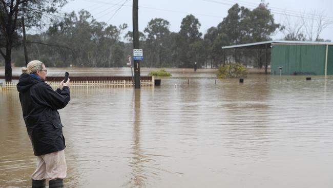 A resident of Old Hawkesbury Road looks on as the street floods. Picture: John Grainger