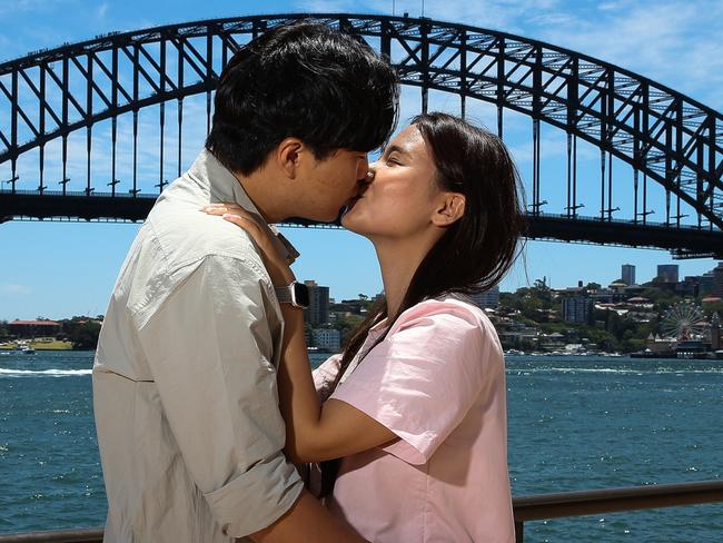 SYDNEY, AUSTRALIA : NewsWire Photos - DECEMBER 23 2024; Korean couple on their honeymoon Selugi Kim and Kyeongwon Lee pose for a photo at the Opera House forecourt with a view of the Sydney Harbour Bridge in the background as new tourism data for NSW is released. Picture: NewsWire/ Gaye Gerard