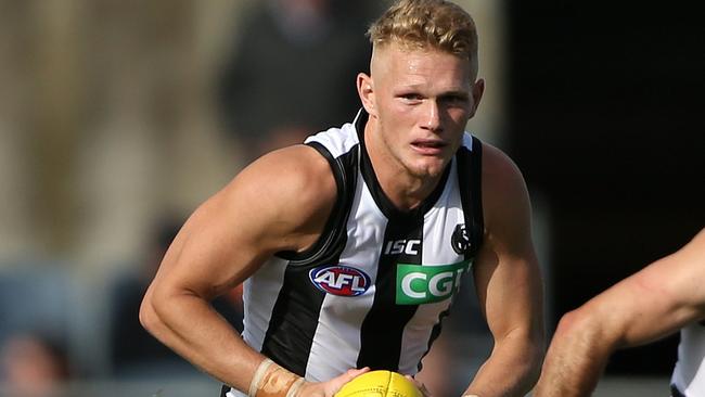 Adam Treloar prepares to take off with ball in hand for Collingwood.