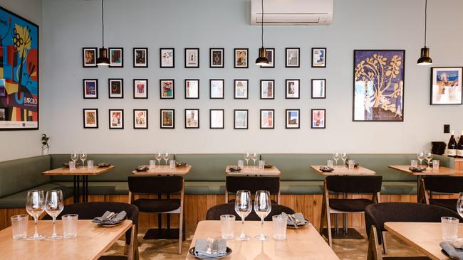 The dining room feels homely, featuring mint green walls adorned with beverage-themed prints, soft lighting and banquettes cleverly designed to double as storage.