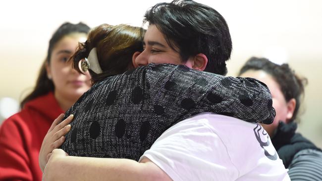 Store owner Filor Firtina (left) is embraced by family outside the store. Picture: Lawrence Pinder
