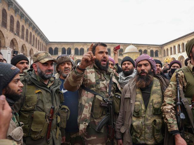 Fighters celebrate in Damascus' Omeyyad mosque on December 8, 2024, after Islamist-led rebels declared that they have taken the Syrian capital in a lightning offensive, sending President Bashar al-Assad fleeing and ending five decades of Baath rule in Syria. (Photo by Rami al SAYED / AFP)