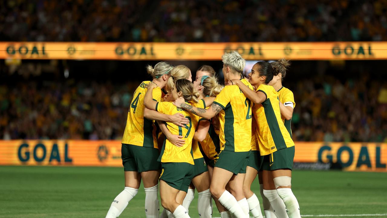 Kaitlyn Torpey is mobbed by teammates after scoring her first goal in Australian colours against Uzbekistan. Picture: Robert Cianflone/Getty Images.