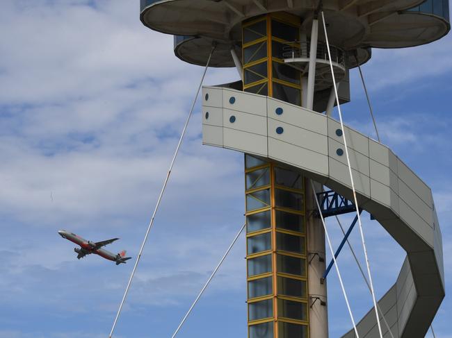 The control tower at Sydney Airport is seen as a plane takes off in Sydney, Friday, March 29, 2019. Flights are slowly resuming after Sydney Airport's air traffic control tower was evacuated after smoke was detected inside. (AAP Image/Peter Rae) NO ARCHIVING