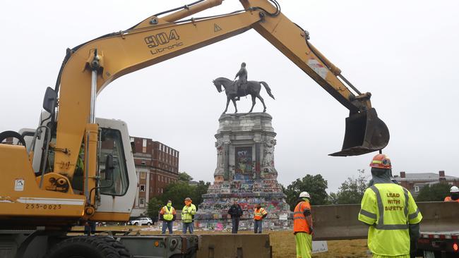 Workers for the Virginia Department of General Services install concrete barriers around the statue of Confederate General Robert E. Lee on Monument Avenue.