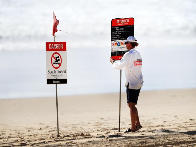 Gold Coast City Council Life Guards erect ’beach closed’ signs on Friday morning. Photo: Scott Powick.