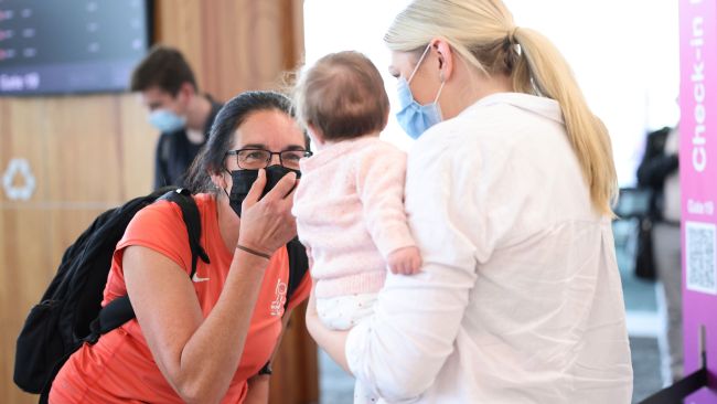 Danielle Brides holds her baby Arabella while her mum Mary Clarke looks on at Adelaide Airport on the first day of South Australia's reopening to the rest of the country. Picture: NCA NewsWire / David Mariuz
