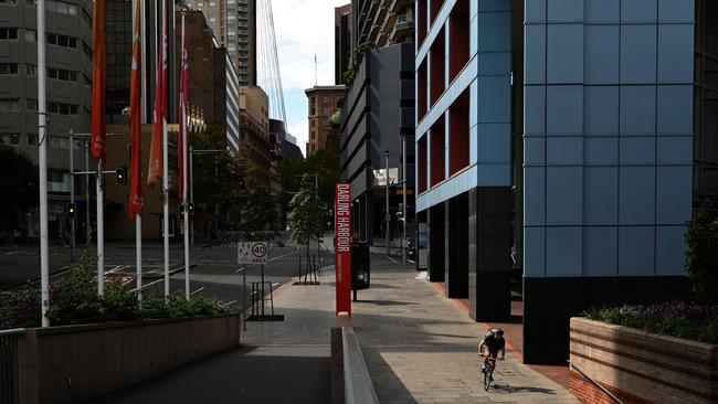 A courier rides down a deserted Market Street in the CBD in Sydney. Picture: Dean Lewins