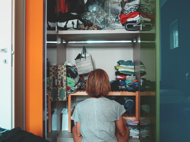 Generic stock image of a woman looking at a cluttered wardrobe, messy home. Picture: istock