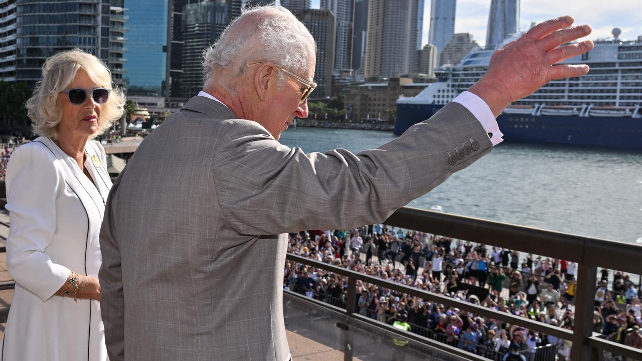 The King waves to the crowd from the Opera House as the Queen watches on. Picture: Saeed KHAN / POOL / AFP